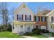 Charming two-story townhome featuring a cozy front porch, red shutters, and a well-manicured lawn at 6212 Windsor Gate Ln, Charlotte, NC 28215