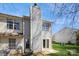 View of the back of a townhome with a chimney, windows, and a sliding door at 6212 Windsor Gate Ln, Charlotte, NC 28215