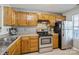 Kitchen showcasing wood cabinets, backsplash, stainless steel appliances, and countertops at 6212 Windsor Gate Ln, Charlotte, NC 28215