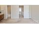 A neutrally decorated room providing access to a bathroom and hallway at 6212 Windsor Gate Ln, Charlotte, NC 28215