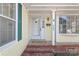 Charming front porch with brick base, featuring a white door and large picture window at 6626 Somersworth Dr, Charlotte, NC 28215