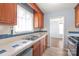 Well-lit kitchen featuring a stainless steel sink and wood cabinetry at 6626 Somersworth Dr, Charlotte, NC 28215