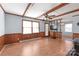 Bright living room with wood floors, wood-paneled walls and trim, and a ceiling fan at 6626 Somersworth Dr, Charlotte, NC 28215