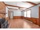 Inviting living room featuring a brick fireplace, ceiling fan and wood-paneled walls and trim at 6626 Somersworth Dr, Charlotte, NC 28215