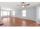 Bright living room with hardwood floors, multiple windows, ceiling fan, and modern lighting at 6626 Somersworth Dr, Charlotte, NC 28215