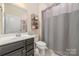 Simple bathroom featuring a vanity, toilet, framed mirror, and tub shower combination with curtain at 7034 Pin Oaks Dr, Denver, NC 28037