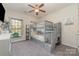 Bright bedroom with a bunk bed, ceiling fan, carpeted floor and a leafy view outside the window at 7034 Pin Oaks Dr, Denver, NC 28037