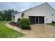 Exterior view of a home's garage with a screened door, concrete driveway, and mature landscaping at 7034 Pin Oaks Dr, Denver, NC 28037