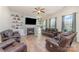 Cozy living room with a fireplace, built-in shelving, and comfortable leather seating under a fan at 7034 Pin Oaks Dr, Denver, NC 28037