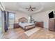 Bright and spacious main bedroom with tray ceiling, wood floors, and two large windows at 7034 Pin Oaks Dr, Denver, NC 28037