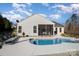 Beautiful backyard showcasing a kidney-shaped pool, screened-in porch, and well-manicured landscaping at 7034 Pin Oaks Dr, Denver, NC 28037