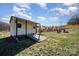 Backyard shed with charming details and adjacent fire pit surrounded by Adirondack chairs at 7034 Pin Oaks Dr, Denver, NC 28037