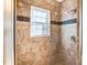 Walk-in shower with brown tile and a built-in seat and shower head at 8005 Bridger Pt, Waxhaw, NC 28173