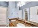 Bathroom featuring a double sink with granite counters, wood cabinets, and view to bathroom at 8005 Bridger Pt, Waxhaw, NC 28173