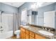 Bathroom featuring a double sink with granite counters, wood cabinets, and shower with tub at 8005 Bridger Pt, Waxhaw, NC 28173