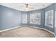 Bright bedroom with neutral carpet, ceiling fan, and three windows providing lots of natural light at 8005 Bridger Pt, Waxhaw, NC 28173