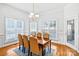 Elegant dining room featuring a chandelier, three large windows, and a wooden table with seating for six at 8005 Bridger Pt, Waxhaw, NC 28173