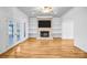 Bright living room with a stone fireplace, built-in shelving, hardwood floors, and double doors to the outside at 8005 Bridger Pt, Waxhaw, NC 28173