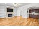 Spacious living room featuring a stone fireplace, built-in shelving, and hardwood floors at 8005 Bridger Pt, Waxhaw, NC 28173