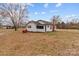 A white, single-story home with a red propane tank sits on a large, grassy lot under a blue sky with scattered clouds at 825 Rock Grove Church Rd, Salisbury, NC 28146