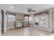 Bright living room with ceiling fan, multiple windows, brick fireplace, and tile flooring at 825 Rock Grove Church Rd, Salisbury, NC 28146