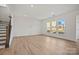 A living room with hardwood floors and three large windows that provide ample natural light at 9508 Coast Laurel Nw Ave, Concord, NC 28027