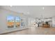 A living room with hardwood floors with an open concept view of the kitchen and multiple windows at 9508 Coast Laurel Nw Ave, Concord, NC 28027