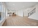 A living room with light hardwood floors with an open concept view of the kitchen at 9508 Coast Laurel Nw Ave, Concord, NC 28027