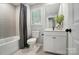 Bright bathroom features a shower-tub, toilet, and a vanity with storage and a large mirror at 9843 Quercus Ln, Huntersville, NC 28078
