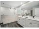 Bright bathroom featuring a double vanity, marble tiled accent wall and glass enclosed shower at 9843 Quercus Ln, Huntersville, NC 28078