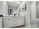Bathroom featuring double vanity with black hardware and an adjacent room featuring a shower at 9843 Quercus Ln, Huntersville, NC 28078
