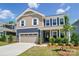 Charming two-story home featuring a covered front porch, attached garage, and manicured lawn at 9843 Quercus Ln, Huntersville, NC 28078