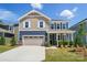 Inviting two-story home featuring a covered front porch, attached garage, and manicured lawn, creating a welcoming curb appeal at 9843 Quercus Ln, Huntersville, NC 28078