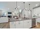 A modern kitchen features white cabinets, gray countertops, and stainless steel appliances, with an island and pendant lighting at 9843 Quercus Ln, Huntersville, NC 28078
