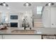 A kitchen island with a stainless steel sink, matte black faucet, and overhead pendant lights, providing a modern design at 9843 Quercus Ln, Huntersville, NC 28078