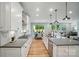 A stylish kitchen with white cabinets, stainless steel appliances, and an open layout that connects to the dining and living areas at 9843 Quercus Ln, Huntersville, NC 28078