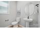 Chic powder room featuring a pedestal sink, round mirror, and modern fixtures for a stylish and functional space at 9843 Quercus Ln, Huntersville, NC 28078