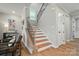 Staircase with wood treads, black metal railings, and natural light from a window at 9843 Quercus Ln, Huntersville, NC 28078