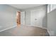 Bedroom with neutral carpet, open door to ensuite, and double door closet at 9930 Cask Way, Huntersville, NC 28078