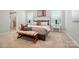 Well-lit bedroom featuring neutral colors, coordinated furnishings, and a comfortable seating bench at 9930 Cask Way, Huntersville, NC 28078