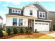 Charming two-story home with a mix of white board and batten, grey siding, stone accents, and a two-car garage at 9930 Cask Way, Huntersville, NC 28078