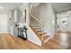 Hallway with wood floors, leading to a staircase and entry, featuring a stylish console table and decor at 9930 Cask Way, Huntersville, NC 28078