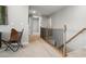 Upstairs hallway with carpet flooring, wood staircase, and a view of multiple entryways at 9930 Cask Way, Huntersville, NC 28078