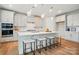 Bright kitchen features a large island with seating, stainless steel appliances, and modern light fixtures at 9930 Cask Way, Huntersville, NC 28078