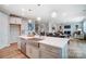 Kitchen island with sink and stainless-steel dishwasher overlooks the dining and living areas at 9930 Cask Way, Huntersville, NC 28078