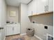Bright laundry room with sink, upper cabinets, and tile flooring at 9930 Cask Way, Huntersville, NC 28078