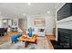 Open-concept living room with a fireplace, modern decor, and wood flooring offers a cozy and stylish space at 9930 Cask Way, Huntersville, NC 28078