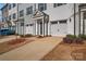 A row of townhomes, each with a one-car garage and covered entrance, showcases modern architecture at 11017 Woodland Creek Way, Charlotte, NC 28262