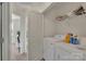 Well-lit laundry room with a washer, dryer, shelving, and cleaning supplies at 11017 Woodland Creek Way, Charlotte, NC 28262