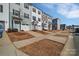 A long shot view down the street of a row of modern townhomes showing curb appeal at 11017 Woodland Creek Way, Charlotte, NC 28262